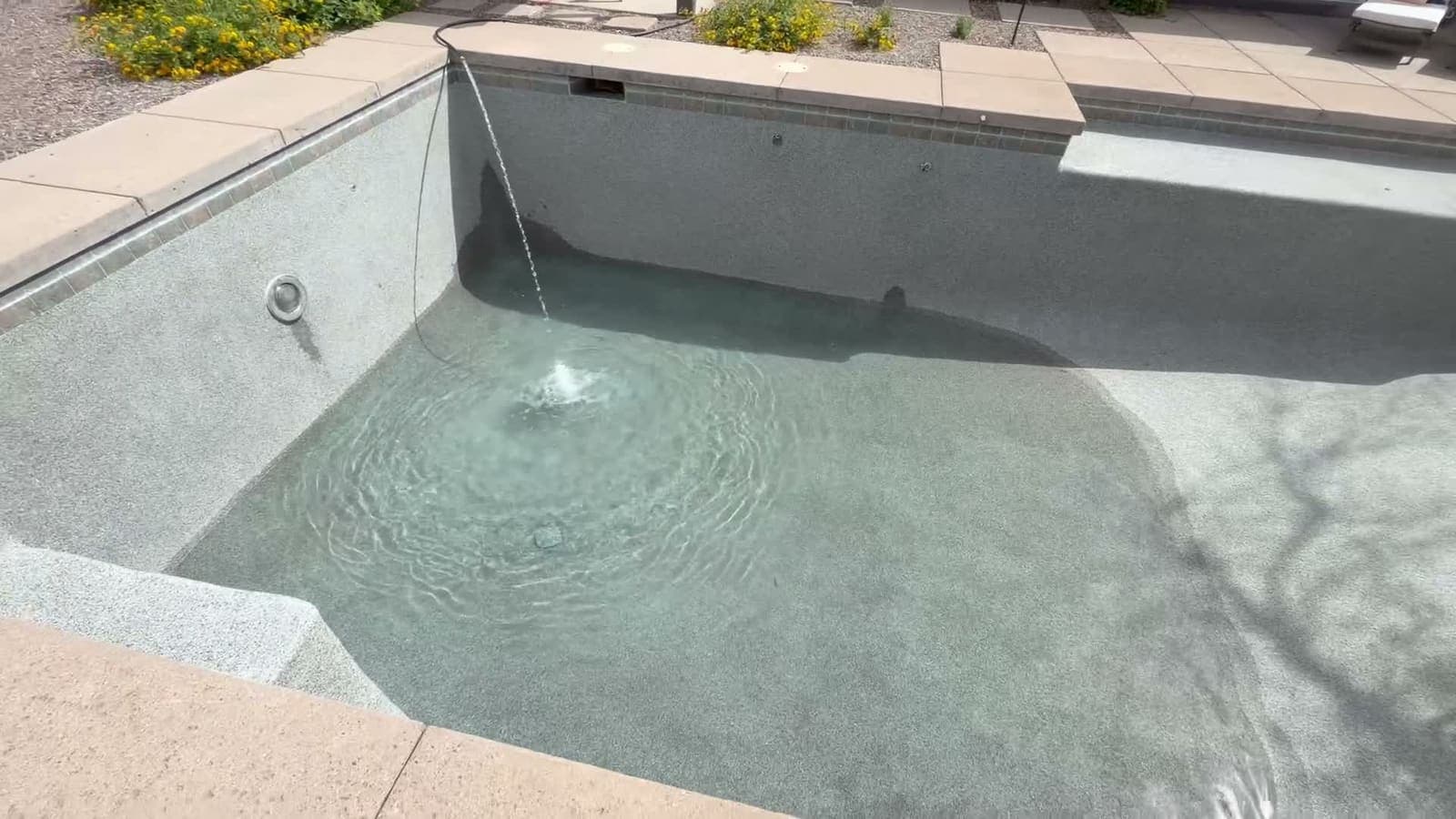 The same pool after the chlorine wash — clean gray pebble, refilling