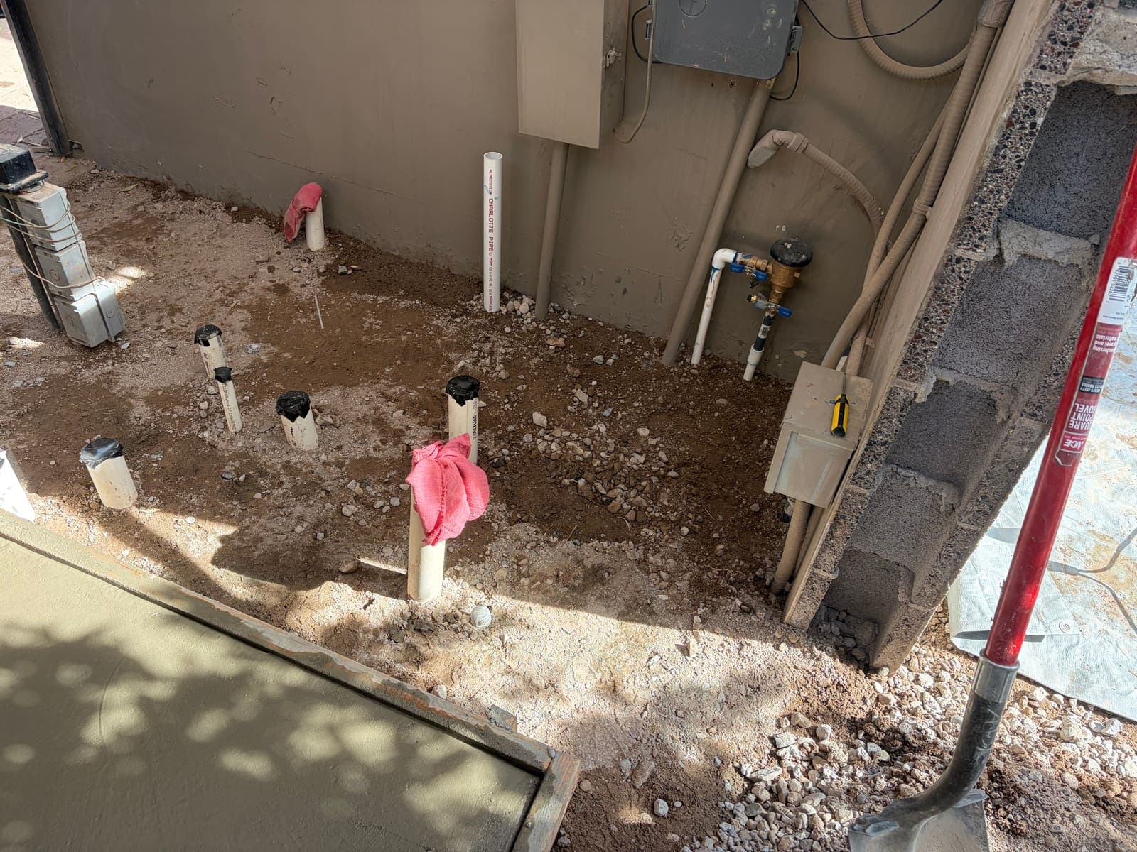 Fresh plumbing stub-outs and new concrete during an equipment pad re-plumb
