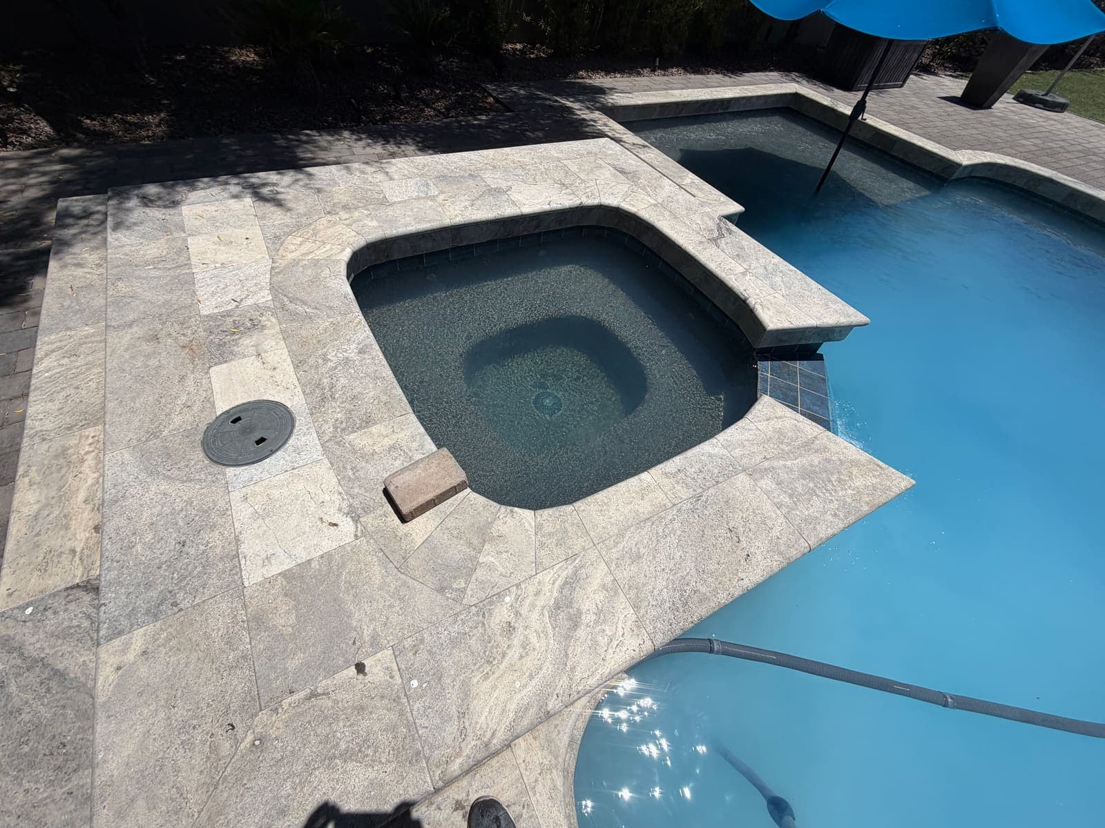 Clean pool and spa with an umbrella on the weekly route, sparkling after service